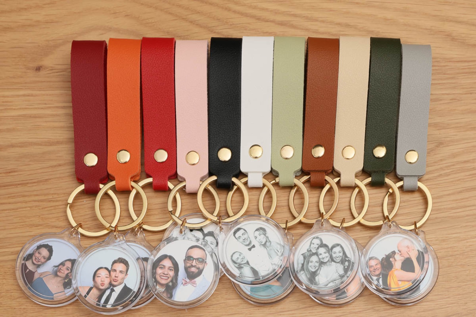 Photo keychains on leather straps arranged on a wooden table